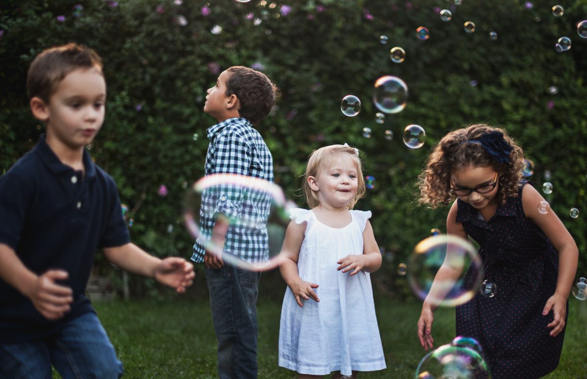 Kids outside blowing bubbles