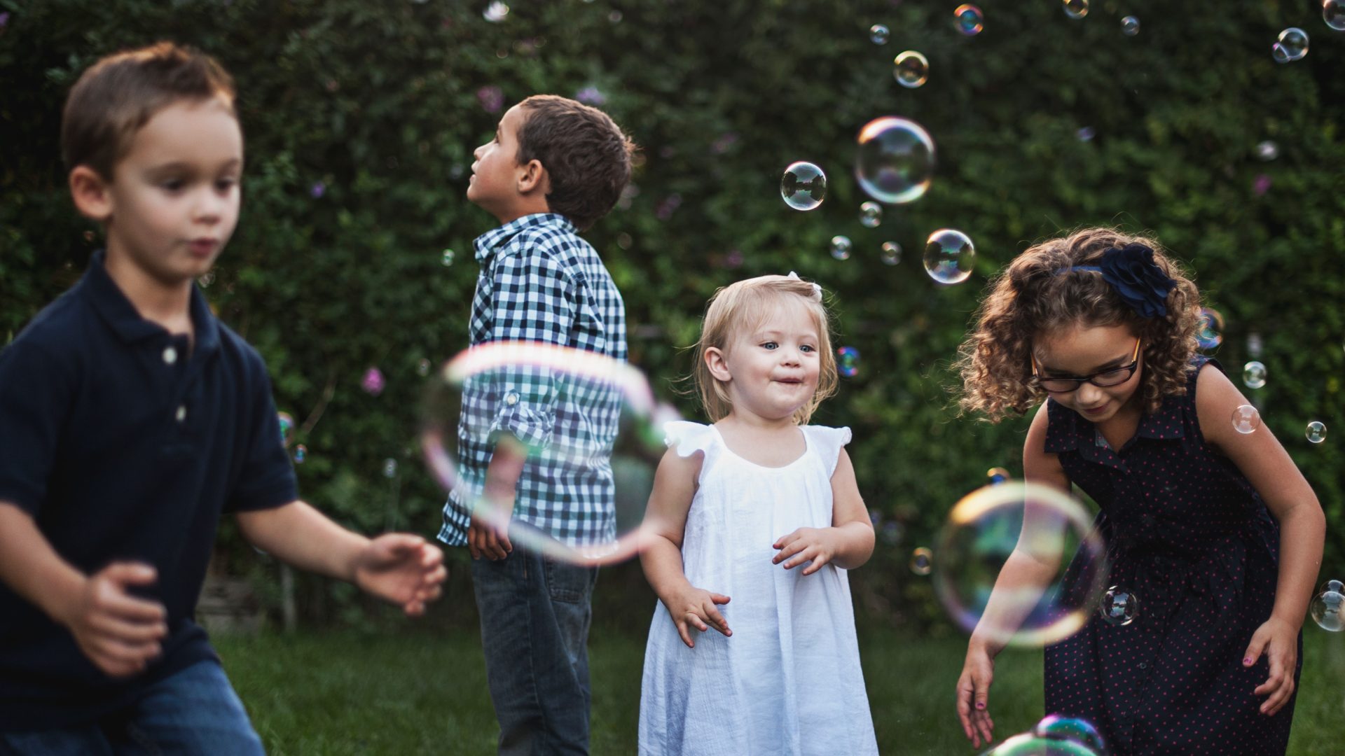 Kids outside blowing bubbles