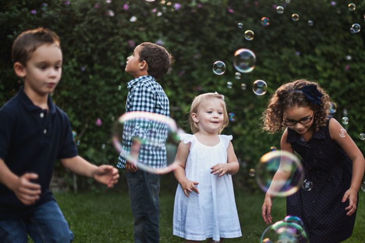 Kids outside blowing bubbles