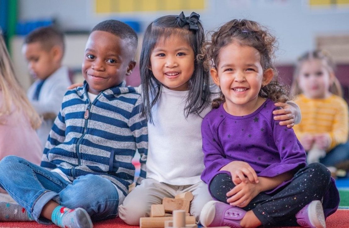 trio of kids on classroom mat